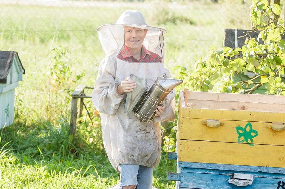 beekeeping for beginners - young teen managing a beehive